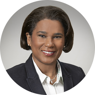 Smiling female clinician in a circular professional headshot with a neutral beige background